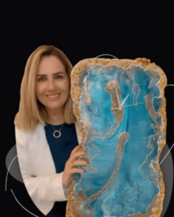 Fabiana Nóbrega segurando uma de suas obras em resina